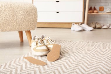 Ortopedik tabanlı şık ayakkabılar ve odada taburesi var.