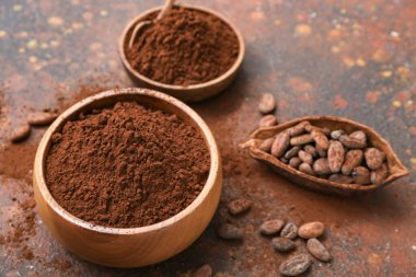 Arkaplanda kakao tozu ve fasulye olan kaseler.