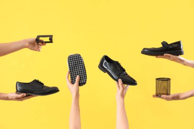 Farklı kırtasiyeye sahip kadın elleri ve sarı arka planda okul ayakkabıları.