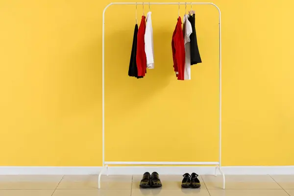 房间里的黄色墙壁旁边穿着时髦校服的破衣烂衫 — 图库照片