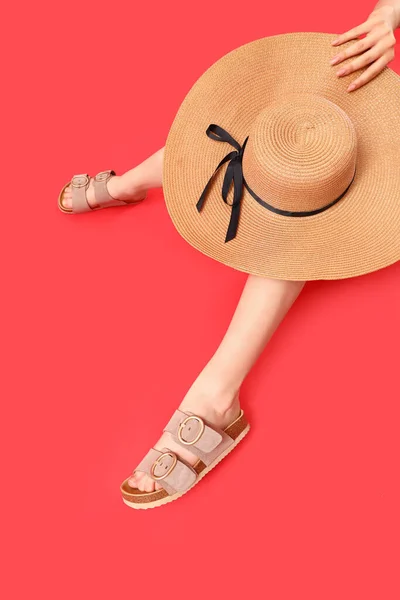 Frauenbeine Stilvollen Sandalen Mit Weidenhut Auf Rotem Hintergrund — Stockfoto