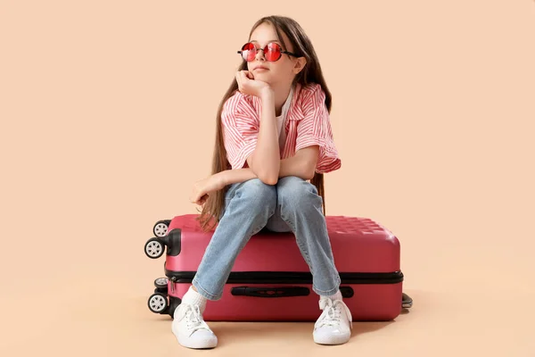 Kleines Mädchen Mit Sonnenbrille Und Koffer Auf Orangefarbenem Hintergrund — Stockfoto