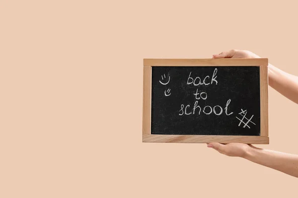 手握黑板的女性手 文字带着米色背景返回学校 — 图库照片