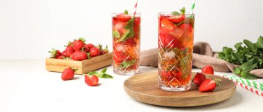 Beyaz arka planda taze çilekli limonata bardakları
