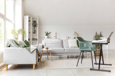 Modern sentezleyici ve kanepeleri olan şık bir oturma odası.