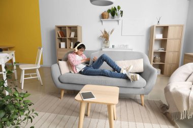 Little boy in headphones using laptop at home
