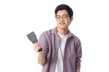 Beyaz arka planda macun bıçağı olan genç bir Asyalı.