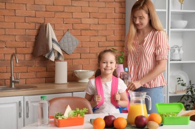 Anne, küçük kızı için mutfakta öğle yemeği hazırlıyor.