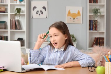 Evde ders alan sevimli küçük kız.