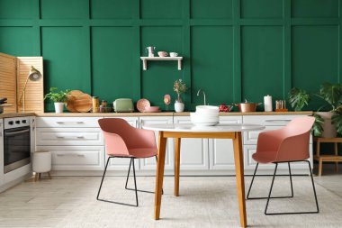 Beyaz tezgahlı ve yemek masalı modern mutfağın içi.