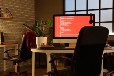 Karanlık ofisteki bilgisayarlı programcının çalışma yeri