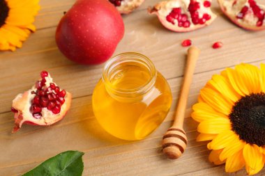 Rosh Hashanah kutlaması (Yahudi Yeni Yılı) için tahta masada bal, nar, elma ve ayçiçeği kavanozu.