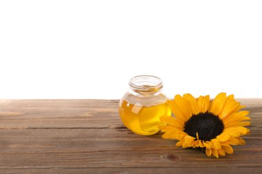 Bal kavanozu ve ayçiçeği ahşap masada beyaz arka planda