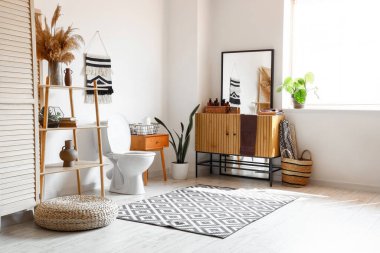 Modern tuvaletin içinde seramik klozet, ahşap makyaj dolabı ve raf ünitesi var.