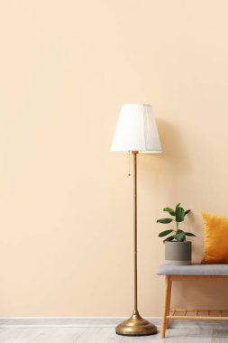 Bej duvarın yanında yumuşak bank olan şık bir oda.