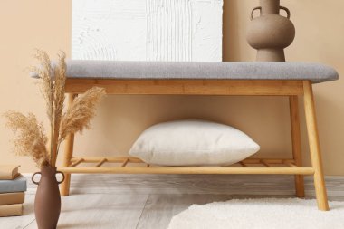 Bej duvarın yanında yumuşak bank olan şık bir oda.