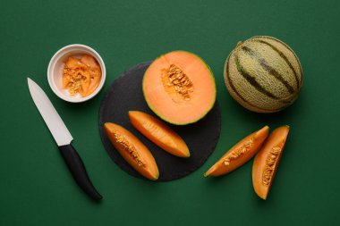 Yeşil arka planda lezzetli olgun kavunlarla kaykay tahtası