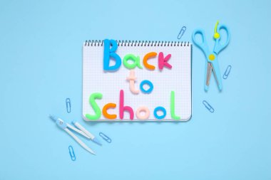 Açık mavi arkaplan üzerinde okula ve kırtasiyeye metin