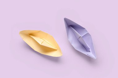Mor arkaplanda renkli origami tekneleri