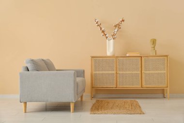 Gri kanepesi ve ahşap büfesi olan oturma odasının içinde.