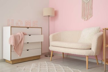 Beyaz kanepesi ve çekmeceleri olan şık bir oturma odası.