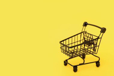 sarı arka plan üzerinde küçük alışveriş sepeti