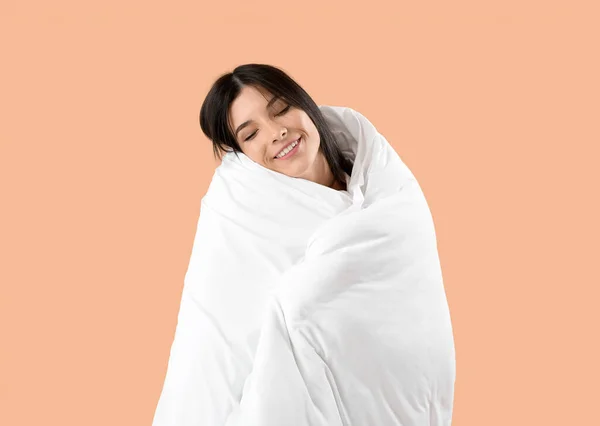 Красивая Счастливая Молодая Женщина Мягким Одеялом Спит Бледно Оранжевом Фоне — стоковое фото
