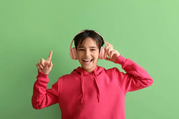 Μικρό Αγόρι Ακουστικά Που Δείχνει Κάτι Πράσινο Φόντο — Φωτογραφία Αρχείου
