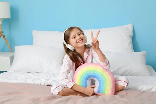 Little Girl Headphones Rainbow Pillow Showing Victory Gesture Bedroom — Stock Photo, Image