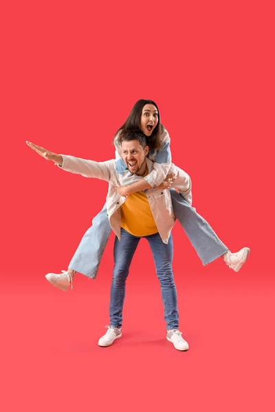 Kırmızı Arka Planda Mutlu Genç Çift — Stok fotoğraf