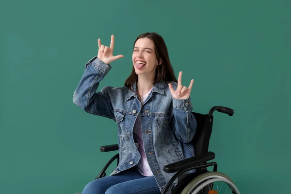 Молодая Женщина Инвалидной Коляске Показывает Рога Дьявола Зеленом Фоне — стоковое фото