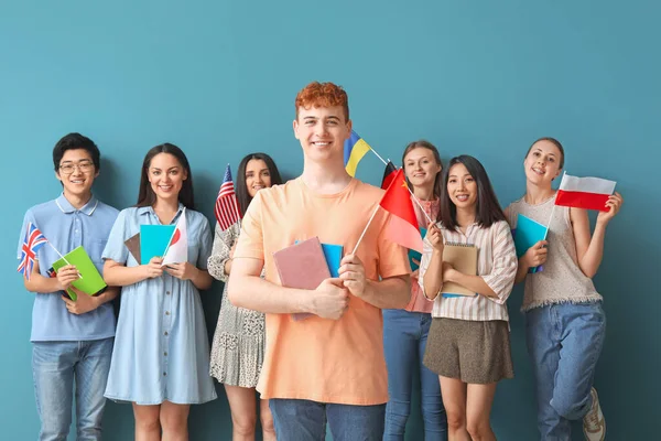 Jóvenes Estudiantes Escuela Idiomas Con Banderas Sobre Fondo Azul — Foto de Stock