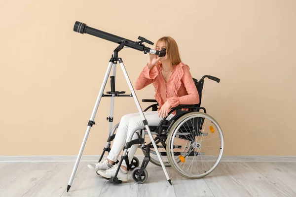 Молодая Женщина Инвалидной Коляске Телескопом Рядом Бежевой Стеной — стоковое фото