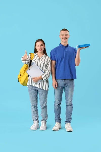 Щасливі Студенти Буферами Книгами Показують Жест Великого Пальця Синьому Фоні — стокове фото