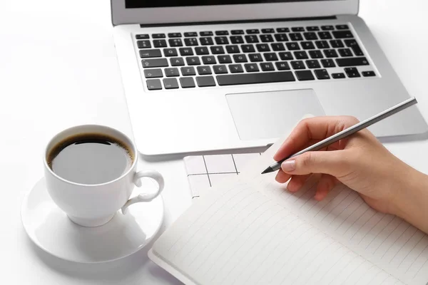 Frauenhand Mit Bleistift Notizbuch Tasse Kaffee Und Laptop Auf Weißem — Stockfoto