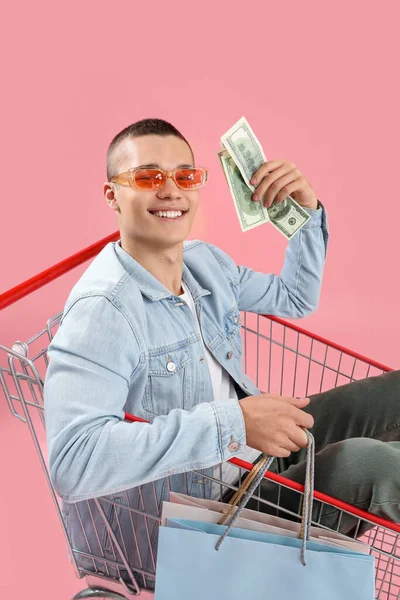 Ung Man Med Pengar Och Väskor Kundvagn Rosa Bakgrund — Stockfoto