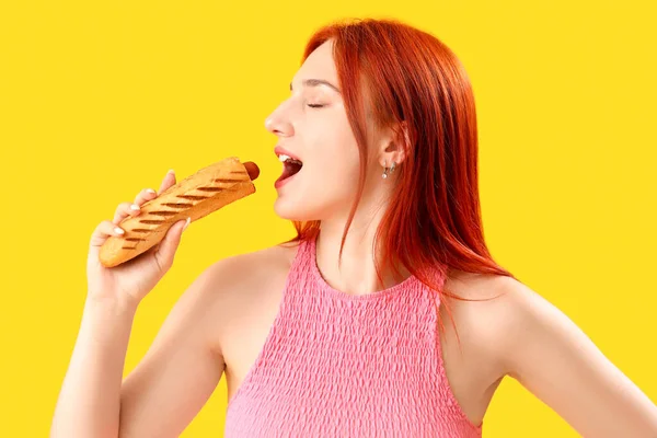 Krásná Mladá Žena Jíst Chutné Francouzské Hot Dog Žlutém Pozadí — Stock fotografie