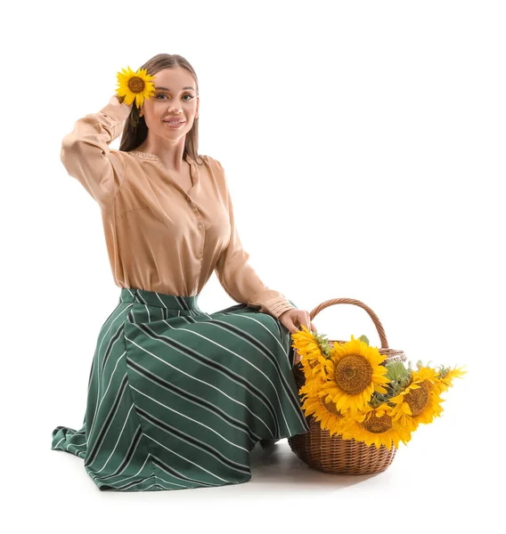 年轻的女人 提着柳条篮 满满一篮美丽的向日葵 坐在白色的背景上 — 图库照片