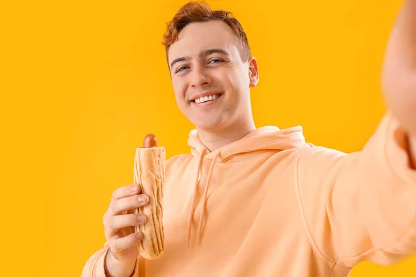 Young Man Tasty Hot Dog Taking Selfie Yellow Background — Stock Photo, Image