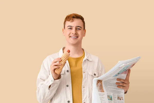 Young Man Tasty Hot Dog Newspaper Beige Background — Stock Photo, Image