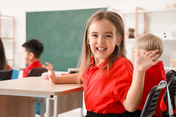 Little school girl in classroom during lesson