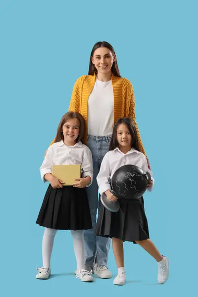Kleine School Meisjes Met Vrouwelijke Leraar Licht Blauwe Achtergrond — Stockfoto