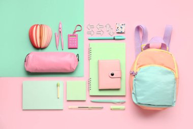 Renkli arka planda farklı kırtasiye malzemesi içeren şık bir okul çantası ve kalem çantası.