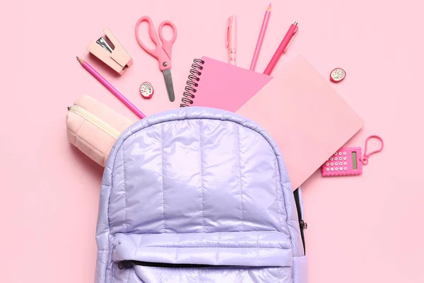 不同粉红背景文具用品的时尚校服背包 — 图库照片