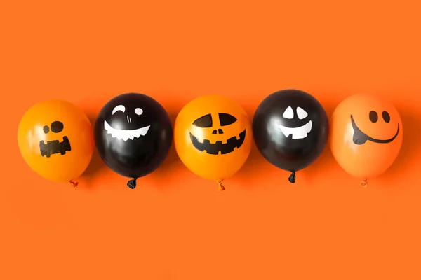 Funny Halloween balloons on orange background