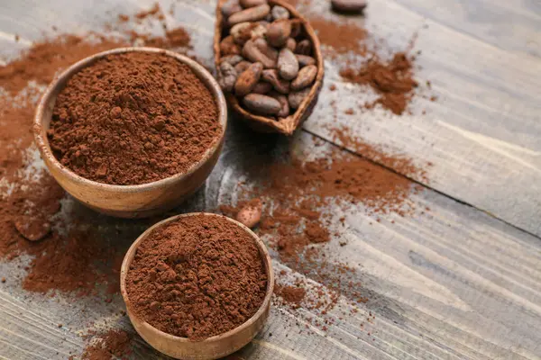 stock image Bowls with cocoa powder on wooden background