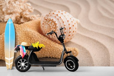 Duvarın yanında tahta sörf tahtası ve deniz kabuğu ve deniz yıldızı olan elektrikli scooter.