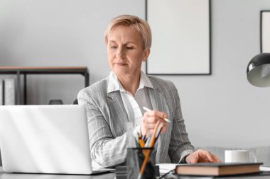 Ofiste çalışan olgun bir iş kadını.