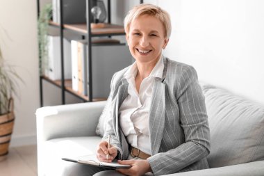 Ofisinde evrakları olan olgun bir iş kadını.