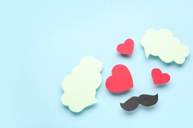 Kağıt bıyık, kalpler ve mavi arka planda boş konuşma baloncukları